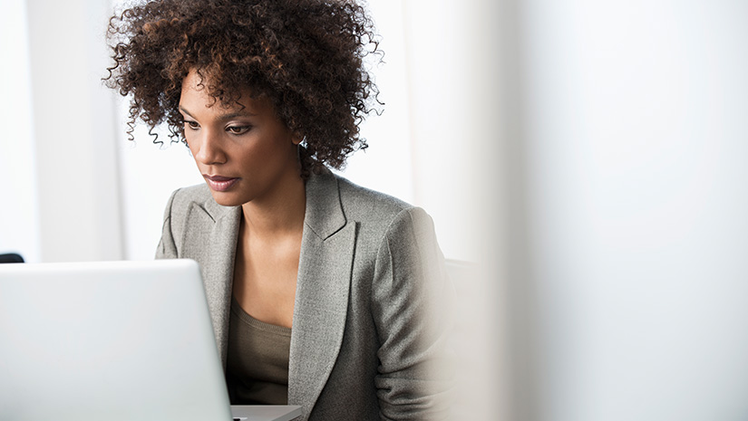 Businesswoman using laptop at desk